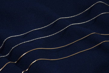 Two golden and silver chains on the deep blue background