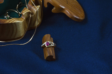 One golden ring and chain near the wooden box on the deep blue background