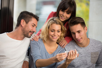 friends looking at smart phones while sitting in cafe