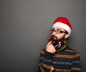 Funny geek with glasses and santa hat thinking - obrazy, fototapety, plakaty