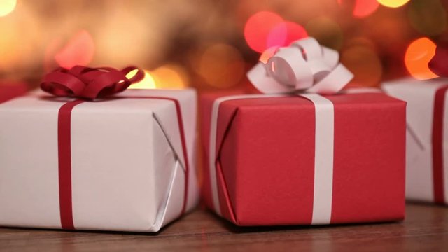 Dolly shot of present boxes against blurry lights - small gifts for christmas or other events
