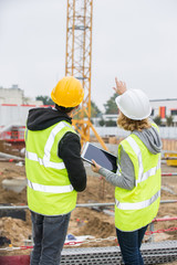 Construction manager and engineer working on building site - 129279232