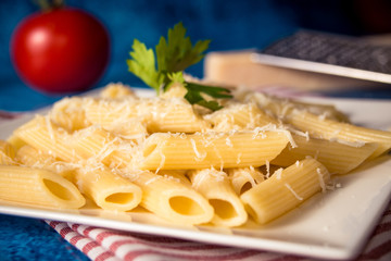 Penne pasta with parmesan cheese on a blue background