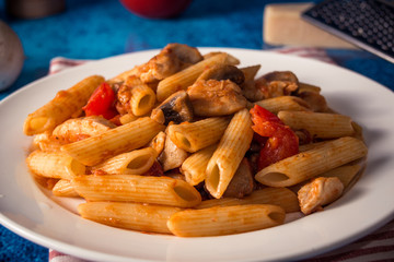 Penne pasta with mushrooms, chicken, tomatoes and cheese parmesa