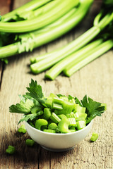 Pieces of fresh celery, vintage wooden background selective focu