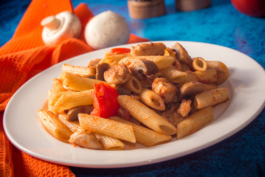 Penne pasta with mushrooms, chicken, tomatoes and cheese parmesa