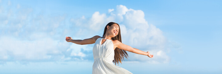 Serene free Asian woman with open arms in freedom or success on sky clouds panorama horizontal banner crop for copyspace. Serenity or bliss.