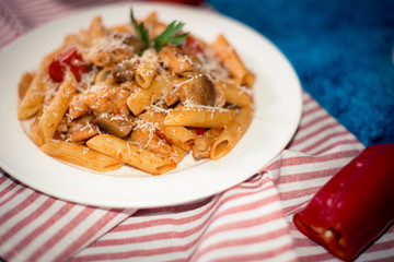 Penne pasta with mushrooms, chicken, tomatoes and cheese parmesa
