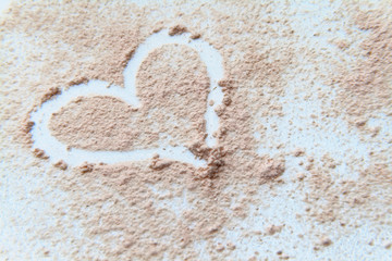 scattered powder on drawing a heart on a white background
