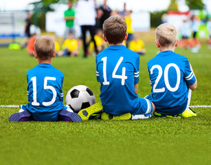 Children Soccer Team Playing Match. Football Game for Kids. Young Soccer Players Sitting on Pitch. Little Kids in Light Blue Soccer Jersey Sportswear