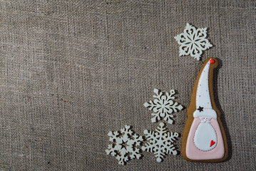 Christmas gingerbread cookie and decorative snowflakes on burlap