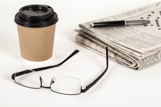 Coffee with newspaper on white background