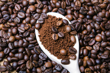 instant coffee in spoon on coffee beans background