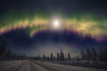Aurora Borealis over the snow covered taiga and road