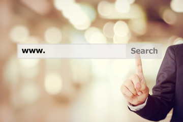Businessman hand touching search bar with www. over blur backgro