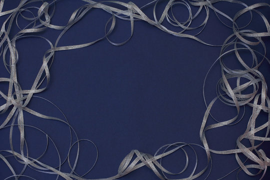 Frame With Silver Ribbon Scrollwork. Christmas/New Year Decorations. Dark Blue Background, Top View, Flat Lay, Copy Space