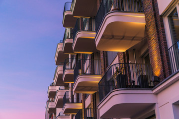 modern and curved balcony on brick facade in the afternoon