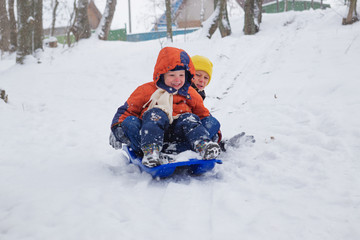 Fototapeta na wymiar kids have fun sledding with snow slides
