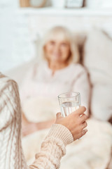Pleasant woman holding glass of water