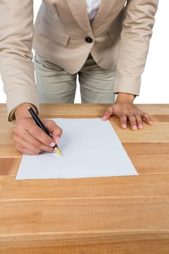 Mid section of businesswoman filling mortgage contract form