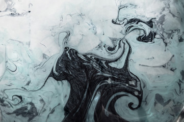 White, black, blue grey ink in water.Twisted designs. Dynamic movement of paint in the water. Top view. Beautiful marble effect. Space for text