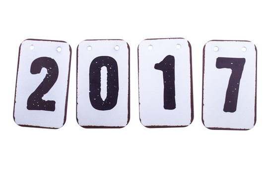 Year 2017 date in numbers made of metal tiles with hanging holes. Isolated on a white background