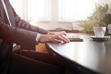 business man hands on a table with tablet, phone and cup of coff