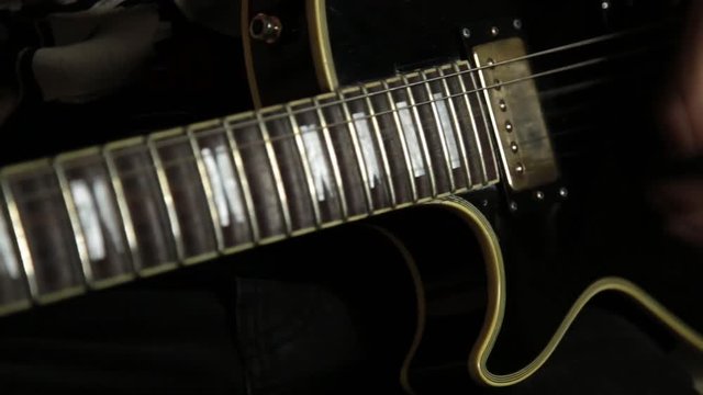 guitarists of a rock band plays on guitar, close-up hands and guitar neck