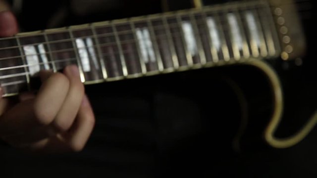 guitarists of a rock band plays on guitar, close-up hands and guitar neck