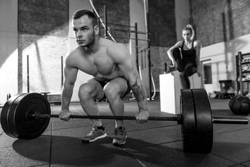 Hard working strong bodybuilder preparing to lift a barbell