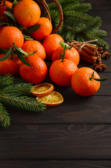 Fototapeta na wymiar Fresh tangerine clementine with spices on dark wooden background, Christmas concept, selective focus, vertical, copy space