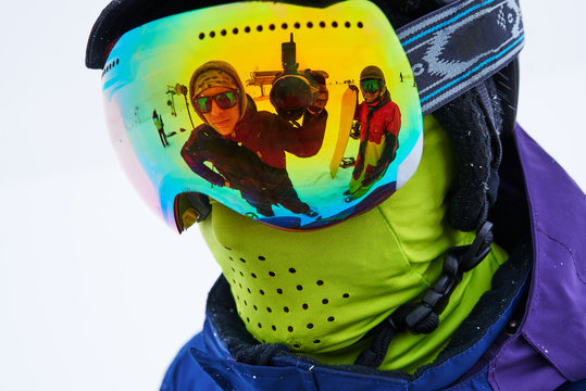 cheerful Face of photographer is reflected in   mask snowboarder, closeup.