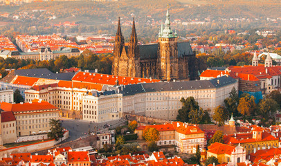 Prague Castle complex with gothic St Vitus Cathedral in the evening time illuminated by sunset,...