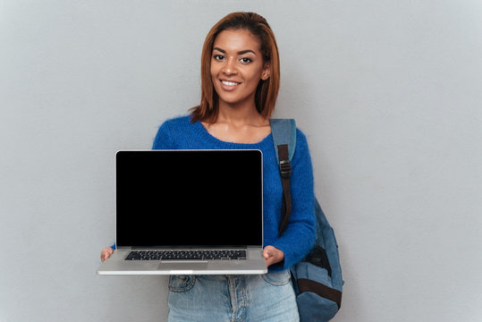 African woman showing blank laptop screen
