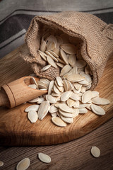 Pumpkin seeds in a sack and spoon.