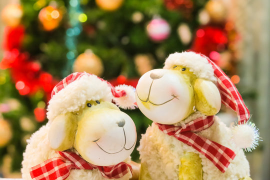 Christmas sheep decoration and christmas tree lighting blur background