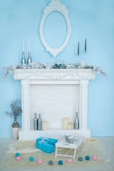 White decorative fireplace decorated in Christmas style. The fur around the fireplace, tray of mugs, gifts and Thai balls. The concept of Christmas