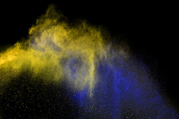 Blue and yellow powder explosion isolated on black background