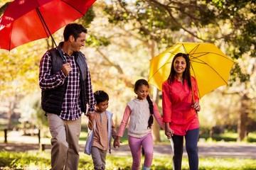 Happy family walking with umbrellas