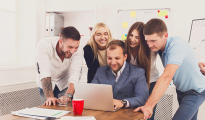 Happy business people team together look at laptop in office