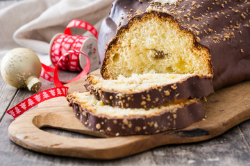 Chocolate yule log christmas cake and christmas ornament on wooden background
