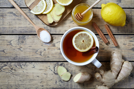 Cup of ginger tea with lemon and honey on wooden background. Top view. Antiviral Healthy drink useful tea. Creative composition.