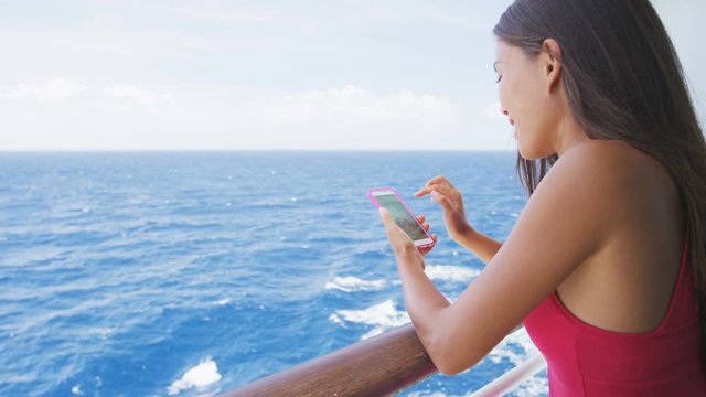 Smart phone close up - woman using smartphone app on cruise ship vacation travel at sea.
