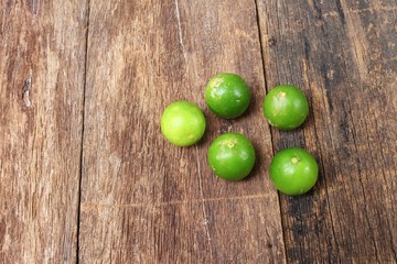 lemon with green on the wooden table, top view