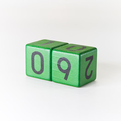 Number nine written on a wooden green cube
