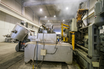 pouring the aluminum metal from the ladle to the loading machine in a large container