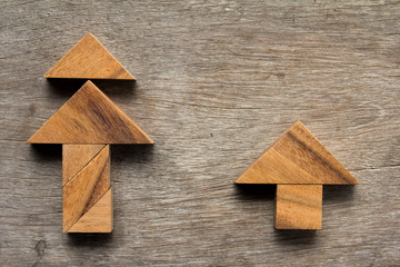 Wooden tangram as Christmas tree and home shape on old wood back