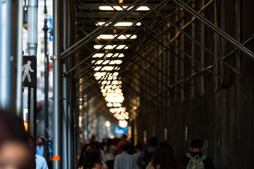 Pedestrians walking busy New York street ans a traffic sign