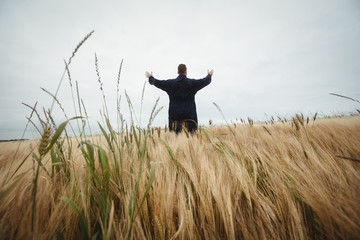 Rear view of farmer standing in the field