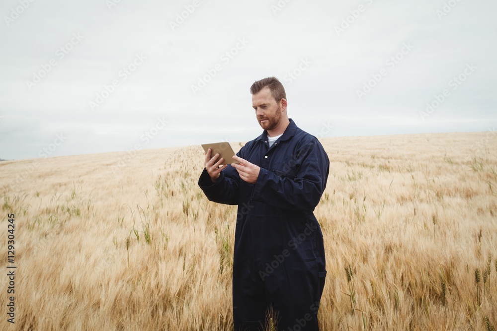 Poster farmer using digital tablet in the field